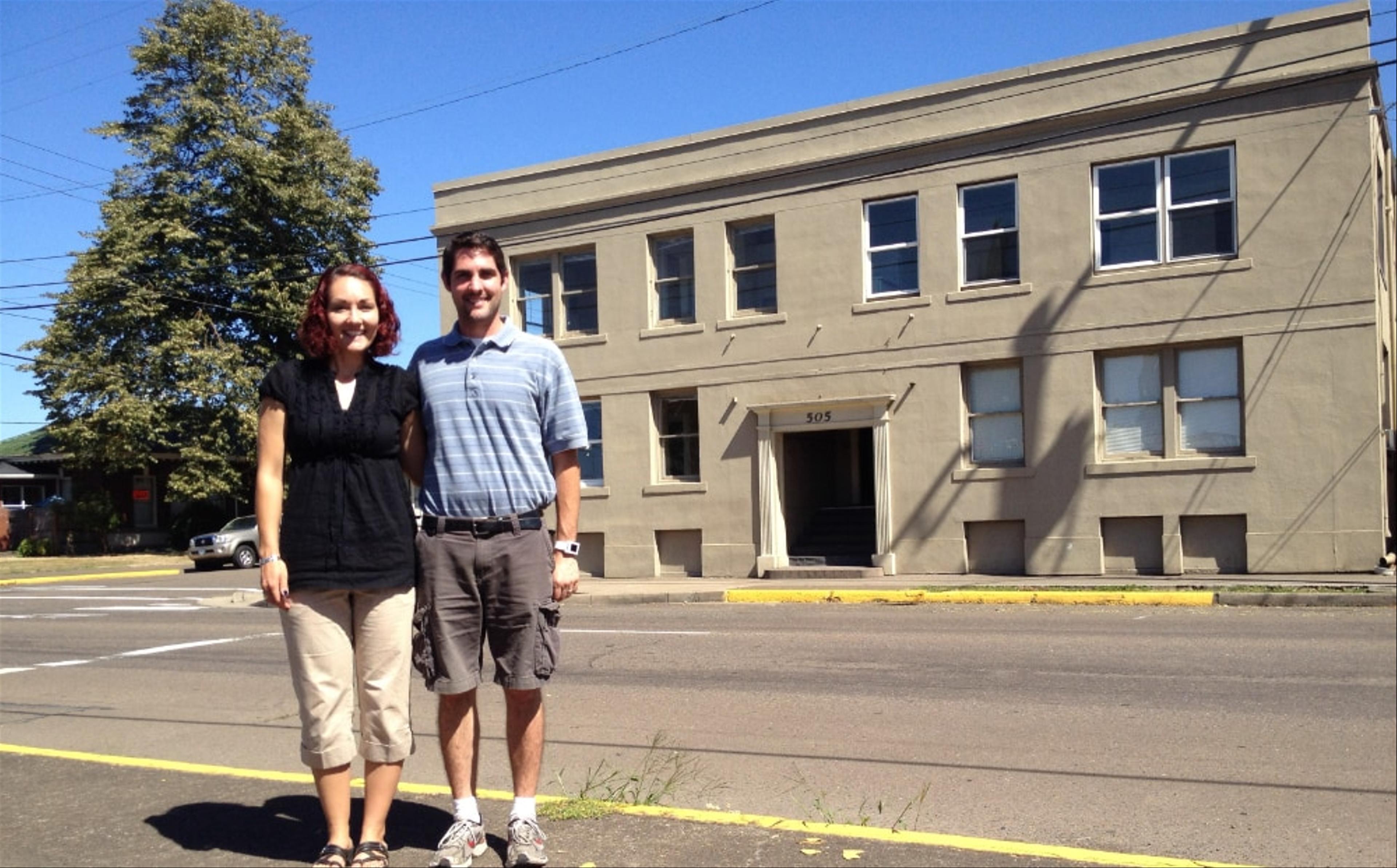 James and Jessi standing in front of the Lyon Apartments